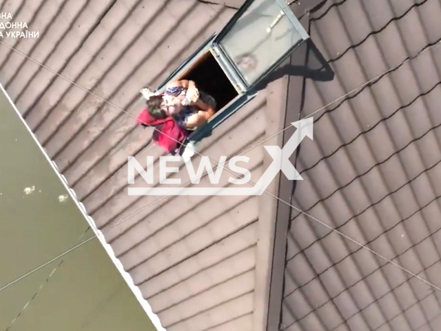 Ukrainian border guards deliver water to the trapped woman from the Kakhovka dam floods in the Kherson Oblast in Ukraine in undated footage. The footage was released by the State Border Service of Ukraine on Thursday, Jun. 8, 2023.
Notes: Photo is screen from a video. (@DPSUkraine/Newsflash)