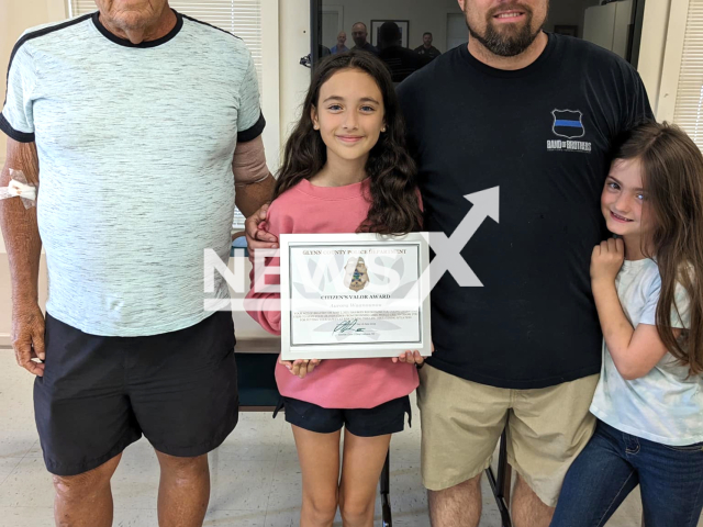 Aurora Waanounou, 10, poses with her Citizen’s Valor Award,  her grandfather and family,   in undated photo. She jumped into a pool to save her unresponsive grandfather that  fell in, and was give an award by police, in  Glynn County, Georgia, USA.  
Note: Police photo. (@GlynnPolice/Newsflash)