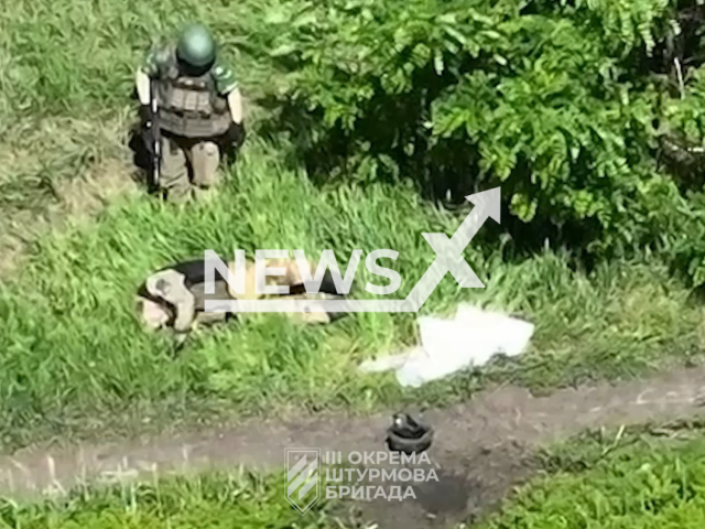 Russian soldier stands near his injured colleague in Ukraine in undated footage. The footage was released by the 3rd separate assault brigade on Monday, June 12, 2023.  Note: Picture is a screenshot from a video (@ab3army/Newsflash)