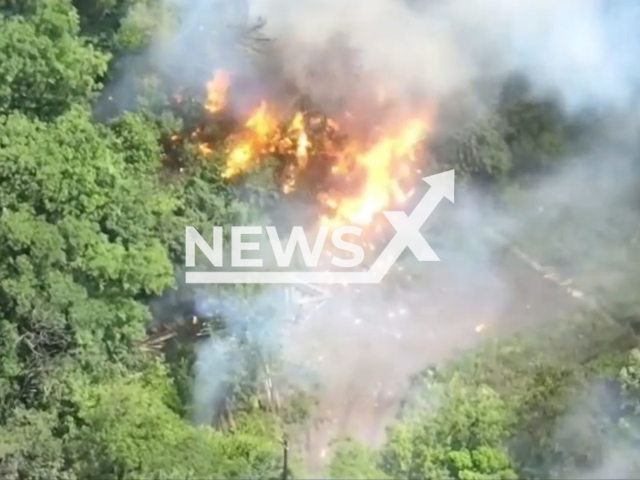 Ukrainian gunners blow up Russian warehouse with hidden among trees ammunition in huge firework in Ukraine in undated footage. The footage was released by the 110th Separate Mechanized Brigade on Tuesday, June 20, 2023. Note: Picture is a screenshot from a video (@110separatebrigade/Newsflash)