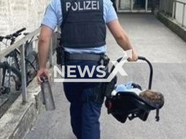 Police officer carries a baby in undated photo. A one-year-old who was left alone in a train from Munich main station was handed over to the federal police in Freising and taken to her parents. Note: Police photo. (Bundespolizei/Newsflash)