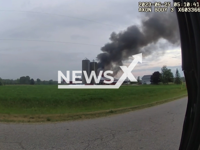 A police officer, Andrew Crabb, rescues three cows from a barn fire in Sturgeon Bay, Wisconsin, USA, Sunday, June 25, 2023. As soon as he spotted smoke coming from a barn at a farm, he stopped, dashed across a field, and entered the barn, finding the cows trapped and mooing in distress. Note: Picture is a screenshot from a video (Sturgeon Bay Police Department/Newsflash)