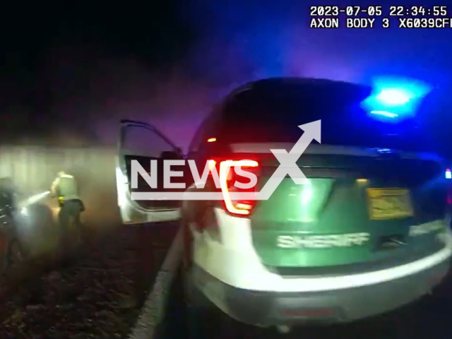 Image shows the moment deputies rescued suspect Mindy Alizabeth Harrison, 30, from a burning car, undated photo. It happened in the area of White City, Jackson County, Oregon State, USA, on Wednesday, July 5, 2023. Note: Photo is a screenshot from a video. (Jackson County Sheriff's Office/Newsflash)