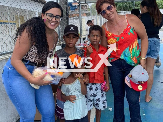 Valdelice da Cruz Almeida, 41, (right) poses with three children, undated. She adopted the children of a murdered friend to prevent their separation. Note: Private photo. (Val Almeida/Newsflash)