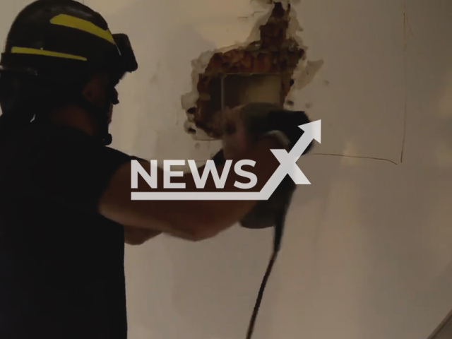 Moment firefighters dig a hole in the wall to rescue people trapped in a lift in Madrid, Spanish capital. Note: Photo is screen from a video. (@EmergenciasMad/Newsflash)