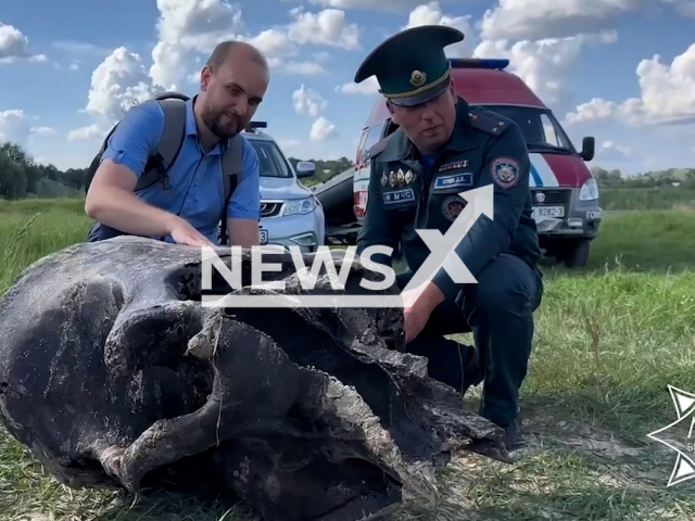 Picture shows Belarussian museum expert and worker of the Ministry of Emergency Situations of Belarus near the remains of a mammoth near the Besed river, Gomel Region of Belarus on Tuesday, Aug. 1, 2023. Rescue divers found the remains of a mammoth in the river. Note: Photo is a screenshot of a video. (@mchs.gov.by/Newsflash)