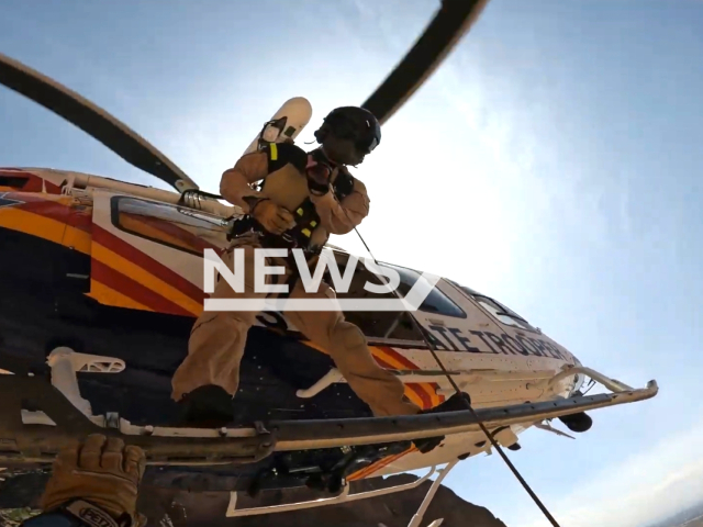 Arizona Department of Public Safety officer hanging from a helicopter in order to rescue a hiker at Siphon Draw Trail in Apache Junction on the 23rd of July 2023. Note: This picture is a screenshot from the video. (Arizona Department of Public Safety/Clipzilla)