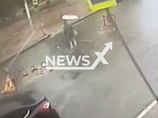 A woman fell into a hole filled with rainwater while crossing the street in Bryansk, Russia, undated. The hole was reportedly formed during a roadwork. Note: Picture is screenshot from a video. (Newsflash)