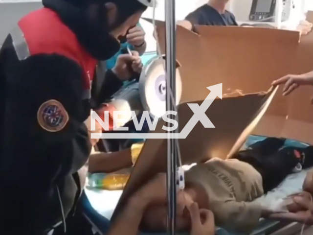 Rescuers help to free the hand of a boy that stuck into a meat grinder in the city hospital No. 3 in Shymkent, Kazakhstan on Wednesday, Aug. 30, 2023. Doctors amputated the child's three fingers. Note: Picture is screenshot from a video. (@shymkent_tjd/Clipzilla)