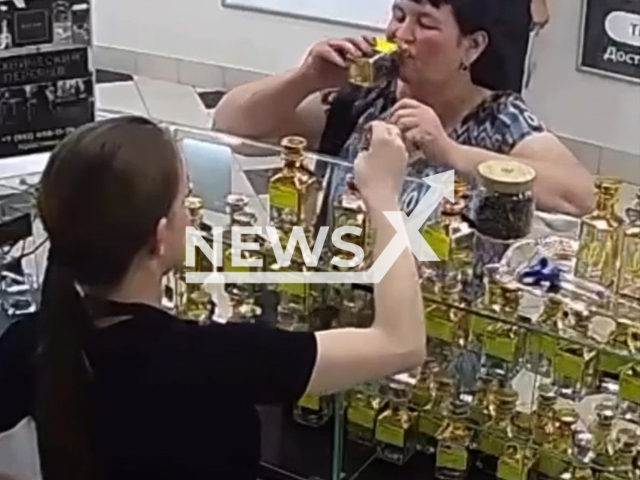 Woman tests perfumes in a store and suddenly drinks of on them in shopping center in Saratov, Russia, undated. Perfume consultant looked at leaving smiling woman with shock.Note: Picture is screenshot from a video. (Newsflash)