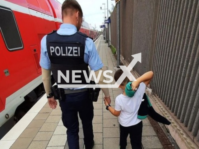 Image shows seven-year-old Maksim with a police officer, undated photo. He was separated from his parents while boarding a train at the Munich Central Station, Germany, on Sunday morning, Sep. 17, 2023. Note: Licensed content. (Munich Federal Police Directorate/Newsflash)