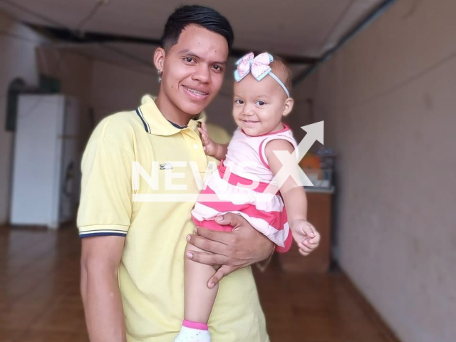 Saimon Souza dos Santos, aged 23, poses with child in undated photo. He was killed in Porto Velho, Brazil. Note: Private photo. (Newsflash)