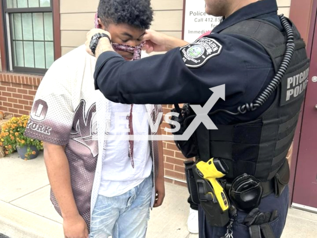 Pitcairn police officer helps teen with his tie in Pennsylvania, US. The teen was preparing for a school dance. Note: Police photo. (Pitcairn Police Department/Newsflash)