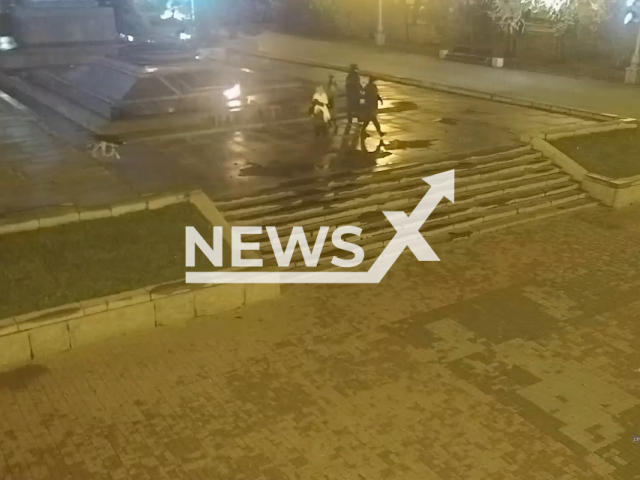 Police officers escort two student girls in Volgograd, Russia on Wednesday, Nov. 15, 2023. They were arrested for lighting a cigarette from the Eternal Flame government monument. Note: Picture is screenshot from a video. (@VOLG_34MVD/Newsflash)