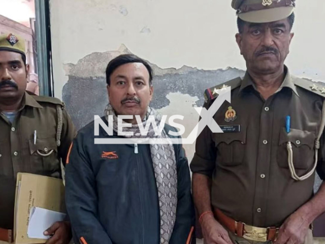 Picture shows the teacher (middle) with police, undated. He was arrested on charges of molesting 16 girl students, he bribed them with candies to indulge in improper acts, in Unnao, India. Note: Private photo. (Newsflash)