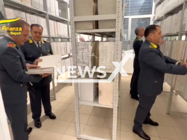 Image shows Financial Police officers investigating, undated photo. They seized more than EUR 607 million (GBP 520 million) from 105 individuals and legal entities in a major fraud operation in the city of Naples, in Italy, in December 2023. Note: Photo is a screenshot from a video. (Financial Police/Clipzilla)