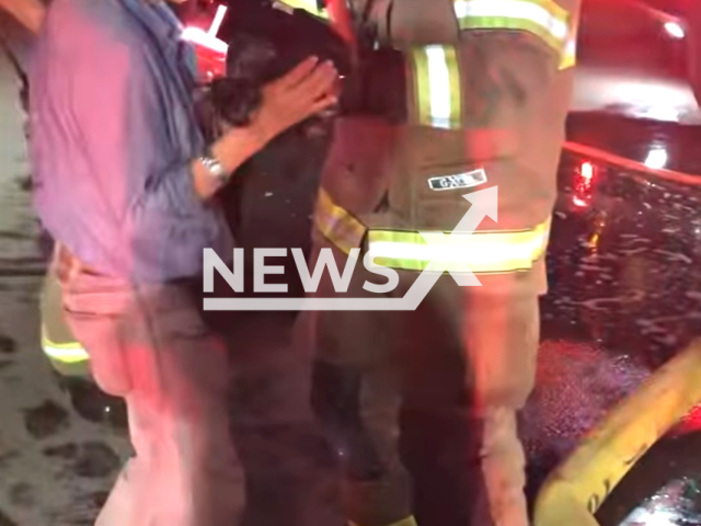 Firefighters  return a kitten they rescued from a fire burning in mobile home, in Fresno, California, USA, on Thursday, Dec. 14, 2023. Note: Photo is a screenshot from video. (@FresnoFireDepartment/Clipzilla)