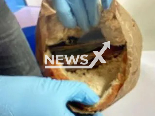 An investigator shows the banknotes in one of the breads, undated. During a check at the Irschenberg rest area on the A8 in Upper Bavaria, Germany, police found 33,000 euros. Note: Prosecution photo. (Munich Public Prosecutor’s Office/Newsflash)