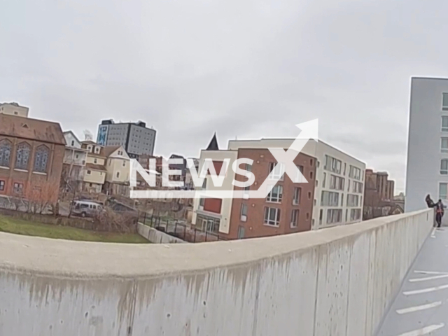 Yonkers PD officers rescue woman in distress on parking garage ledge in Yonkers, New York on 31 January. Note: Picture is a screenshot from the video. (Yonkers Police Department/ClipzillaYonkers Police Department/Clipzilla)