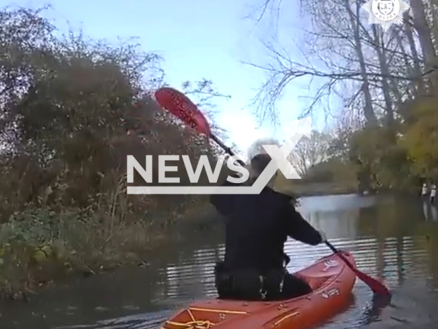 PC Ellison and PC Parkin use kayaks to wade through flood waters and help a stuck driver more than three times the legal alcohol limit, in Bognor Regis, UK. Note: Picture is a screenshot from the video. (Sussex Police/Clipzilla)