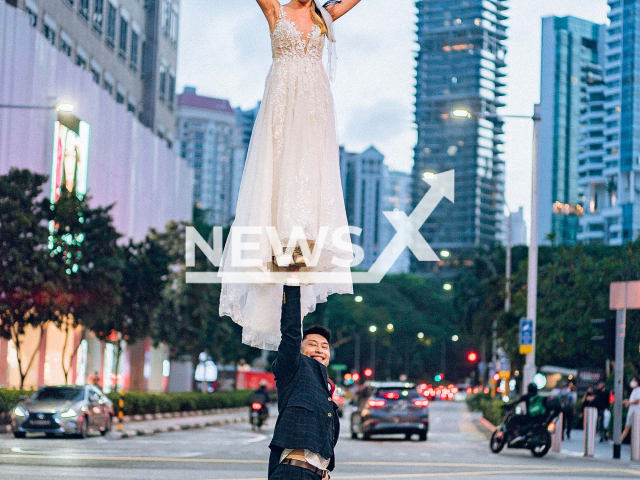 A couple in Singapore did an acrobatic cheerleader pose during a wedding photoshoot along Orchard Road on 27th February 2022. Note: Picture provided to us by Denise (@heystranger.photography, @denisealexis/Newsflash)