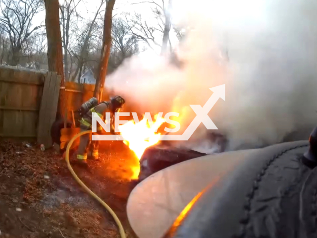 Fire fighters put out a fire near a building in Muskegon Heights, Michigan, USA. Note: Picture is a screenshot from the video. (Muskegon Heights Fire Dept/Clipzilla)