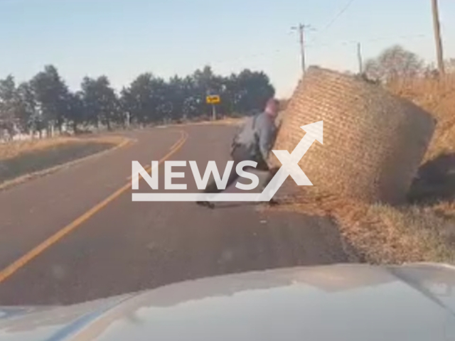 Trooper Isaiah moves hay bail off road, in Missouri, USA. Note: Picture is a screenshot from the video. (Missouri State Highway Patrol/Clipzilla)