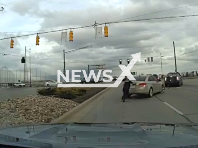 Police officers assist with a car stuck in the middle of a major thoroughfare in Fishers, Indiana, USA, on Tuesday, March 5, 2024. Note: Picture is a screenshot from the video. (Fishers Police Department/Clipzilla)