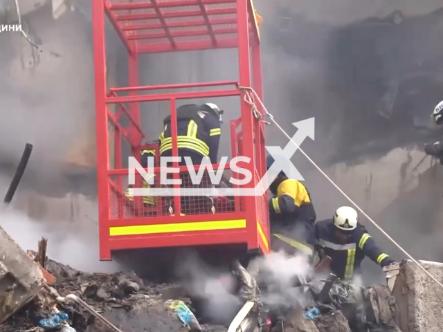 Rescuers remove a body at the site of debris removal in a five-story residential building, in Sumy, Ukraine.Note: Picture is screenshot from a video. (Ministry of Internal Affairs of Ukraine /Clipzilla)