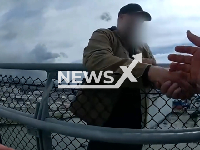 Police officers stop a man attempting to commit suicide off a bridge, in Long Beach, California, USA.Note: Picture is screenshot from a video. (Long Beach Police Department/Clipzilla)