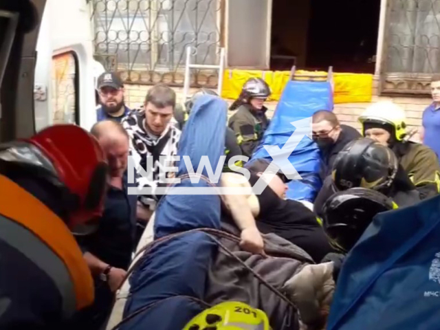 Rescuers pull overweight man Maksim, 54, from his apartment in Moscow, Russia on Thursday, April 11, 2024. The man felt sick, called ambulance but cant get through the door. Note: Picture is a screenshot taken from a video. (@mchs_official/Newsflash)