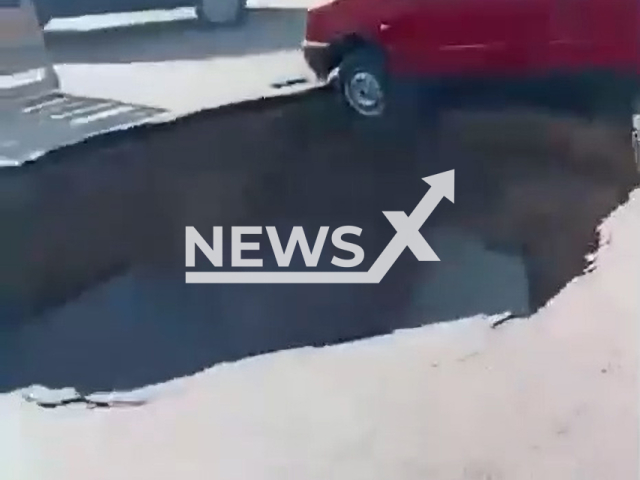 Footage shows gigantic deep hole in the middle of the road in Uryupinsk, Russia, undated. A car almost got into the hole.Note: Picture is screenshot from a video. (Newsflash)