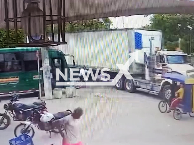 Motorcyclist nearly hit by lorry after losing control in Barranquilla, Colombia, undated. The scene was captured on a CCTV camera.Note: Picture is screenshot from a video. (Newsflash)