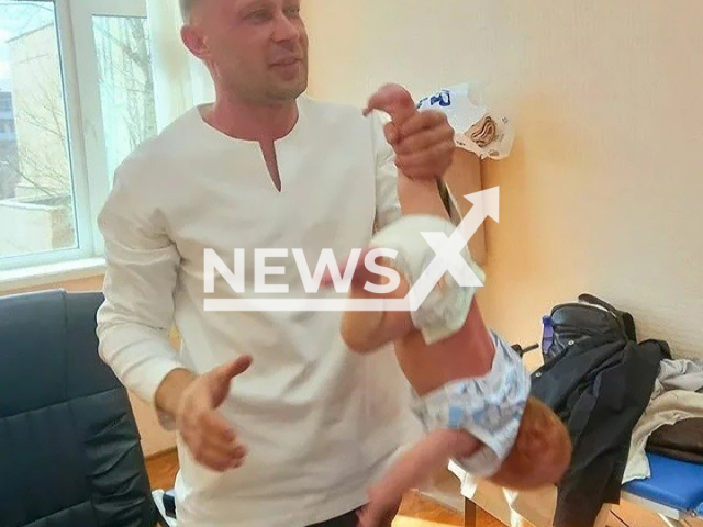 Chiropractor and traditional healer Evgeniy Krotenko from Krasnokamensk, Russia holds a baby upside down, undated. He doesn't have the permission from the Ministry of Health. Note: Private photo taken from local media. (Newsflash)