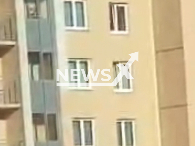 A man, 36, hangs a two-year-old child by her feet from a 13th floor window of residential building in Saint Petersburg, Russia on Tuesday, June 18, 2024. The man was detained.Note: Picture is screenshot from a video. (@spb_police78/Newsflash)