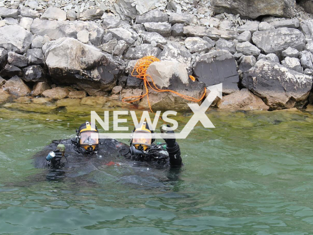 Image shows two divers posing with grenades in their hands, undated photo. Czech Police were cleaning debris in Bosnia. Note: Licensed content. (Police of the Czech Republic/Newsflash)