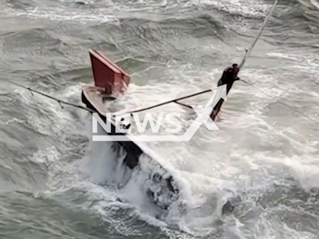 Rescuers rescue a fisherman from a sinking boat near Wafangdian, Liaoning, China, Tuesday, Oct. 15, 2024. The boat sank due to the strong waves. Note: Photo a is screenshot from a video(AWR/NewsX)