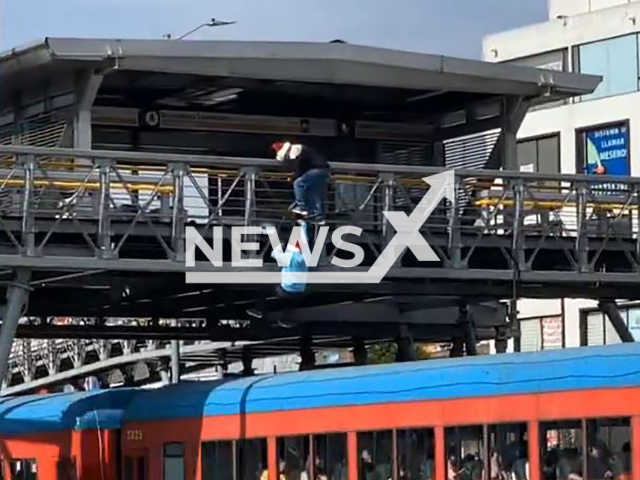 Two young men jump from a pedestrian bridge onto the roof of a moving train in Bogota, Colombia, Dec. 15, 2024. Note: Photo a is screenshot from a video(NF/newsX)