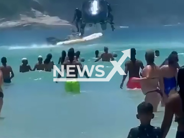 Police officer drops the rifle from helicopter into the sea and swimmer returns the weapon in Cabo Frio in Rio, Brazil, Tuesday, Dec. 31, 2024. Bathers recorded the incident. Note: Photo is a screenshot from a video. (NF/newsX)