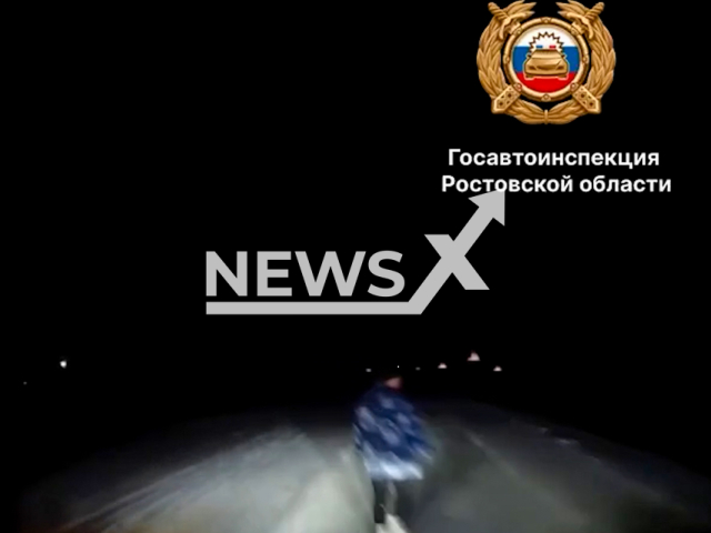 This image is a screen grab of the video supplied titled NewsX-DarkRoadHit-01.mp4: Footage shows a Volkswagen Touareg hitting a woman walking in the middle of the road on the Donskoy-Tselina highway in the Zernograd district, Rostov Oblast, Russia on Sunday, Feb. 23, 2025. (Clipzilla/NX)