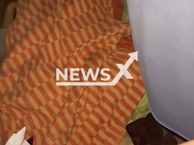 Officers discover man's corpse lying on the sofa in Belgorod-Dnestrovskyi, Ukraine, March 19, 2025. According to his mother he died on March 8. Note: Photo is a screenshot from a video. (@bdvarta/Newsflash/NX)