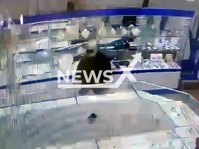 This image is a screen grab of the video supplied titled NewsX-FailedJewHeist-01.mp4: CCTV footage shows eyewitnesses helping detain an axe-wielding jewelry store robber after a quick-thinking SUV driver rammed the criminal's motorcycle, allowing bystanders to capture him in Vanino, Khabarovsk Krai, Russia on Wednesday, Apr. 23, 2025.(Clipzilla/NX)