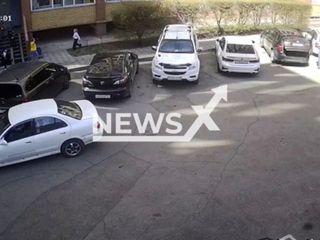This image is a screen grab of the video supplied titled NewsX-ParkedEightRun-01.mp4: CCTV shows a Nissan hitting an 8-year-old girl who ran out from behind a parked car while playing in a yard on Krasnodarskaya Street in Krasnoyarsk, Russia on Tuesday, Apr. 29, 2025.(Clipzilla/NX)