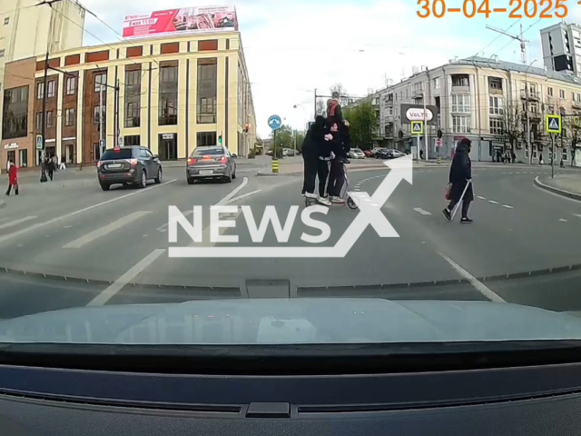 This image is a screen grab of the video supplied titled NewsX-FourScooter-01.mp4: Dashcam footage shows four people riding an electric scooter at an intersection in Ivanovo, Russia on Wednesday, Apr. 30, 2025.(Clipzilla/NX)