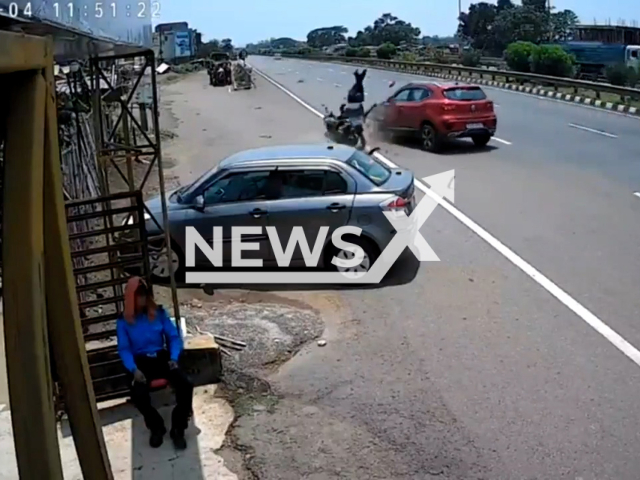 This image is a screen grab of the video supplied titled NewsX-WrongSideCrash-01.mp4: CCTV footage shows a biker crashing head-on into a car after riding on the wrong side of the road in Panikoili, Jajpur, India on Sunday, May 4, 2025.(Clipzilla/NX)