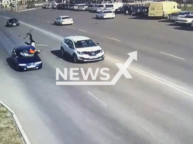 This image is a screen grab of the video supplied titled NewsX-JanHighway-01.mp4: CCTV footage shows a janitor being hit by a car while crossing the highway in Sayansk, Irkutsk Oblast, Russia on Wednesday, May 7, 2025. (Clipzilla/NX)
