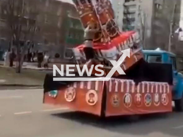 This image is a screen grab of the video supplied titled NewsX-KremlinGirl-01.mp4: A model of the Kremlin installed in the trunk of a truck falls on a girl during a parade in Khabarovsk Krai, Russia, undated. Footage shared on VKontakte on Sunday, May 11, 2025.(Clipzilla/NX)