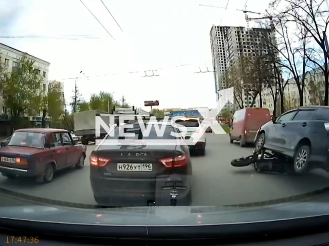This image is a screen grab of the video supplied titled NewsX-BikeBiker-01.mp4: Dashcam footage shows a car hitting a motorcycle, the rider miraculously escapes without injury in Yekaterinburg, Russia on Tuesday, May 6, 2025. (Clipzilla/NX)