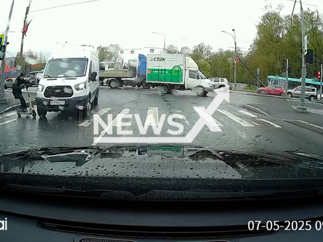 This image is a screen grab of the video supplied titled NewsX-VanHit-01.mp4: CCTV footage shows a scooter rider getting struck by a van while crossing the intersection in Saint Petersburg, Russia on Wednesday, May 7, 2025. (Clipzilla/NX)