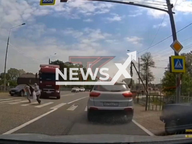 This image is a screen grab of the video supplied titled NewsX-TruckMissPed-01.mp4: Dashcam shows a truck narrowly missing pedestrians at a zebra crossing in Stanitsa Kholmskaya, Kuban. Russia on Saturday, May 10, 2025.(Clipzilla/NX)